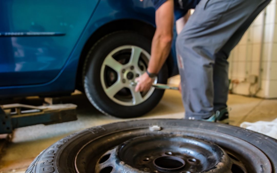A technician puts a new tire on a car.